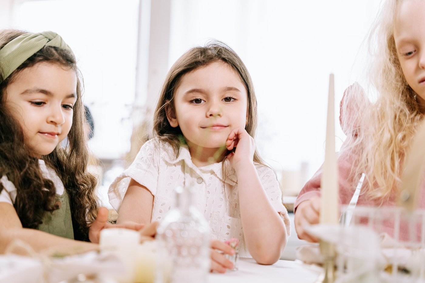 A small group of young girls working together at a craft table